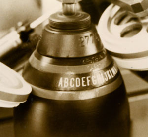 Marking of text and coloured stripe on an ogive of gas bottle or projectile in armament.